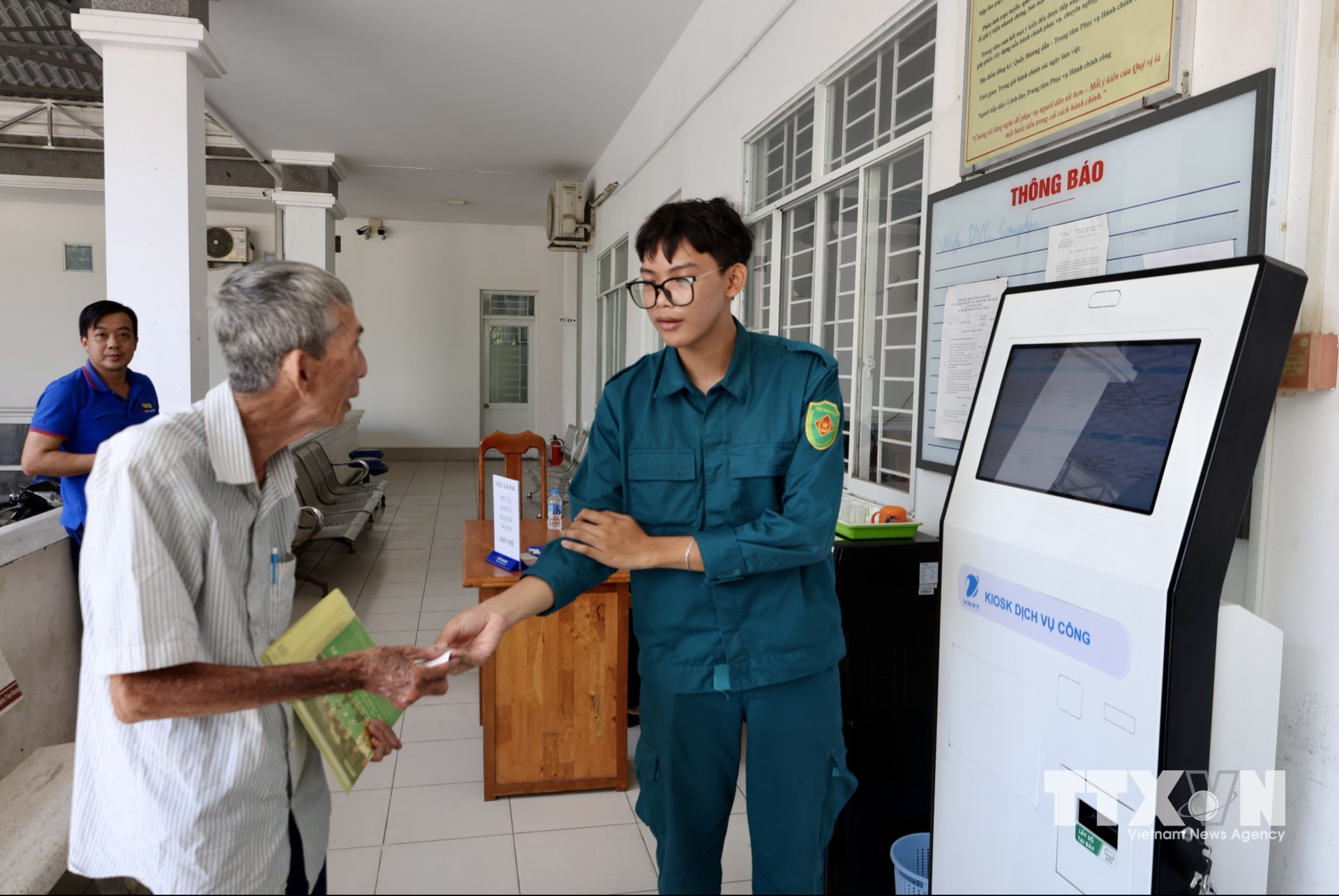 Người dân được hỗ trợ lấy số thứ tự và hướng dẫn quy trình làm thủ tục hành chính tại Trung tâm Phục vụ hành chính công phường Long Xuyên (An Giang). (Ảnh: Thanh Sang/TTXVN)